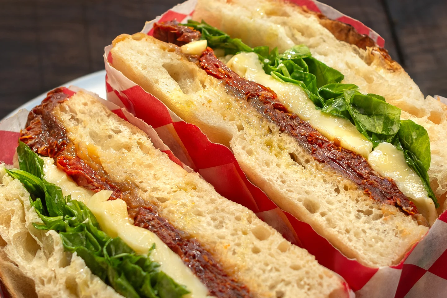 Detalle del pan y el relleno de un sándwich con hojas verdes