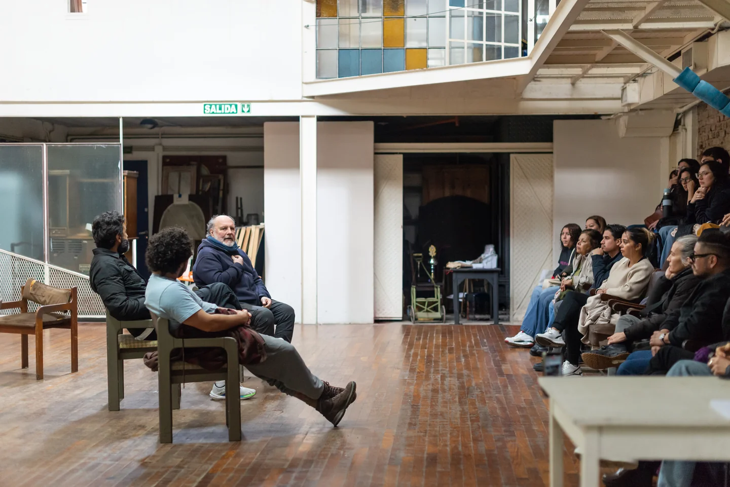 Vista amplia de un encuentro con personas sentadas frente a asistentes en una sala